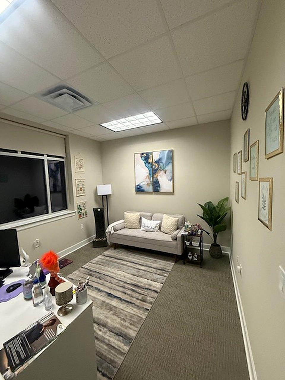 A consultation room with a sofa and an art wall